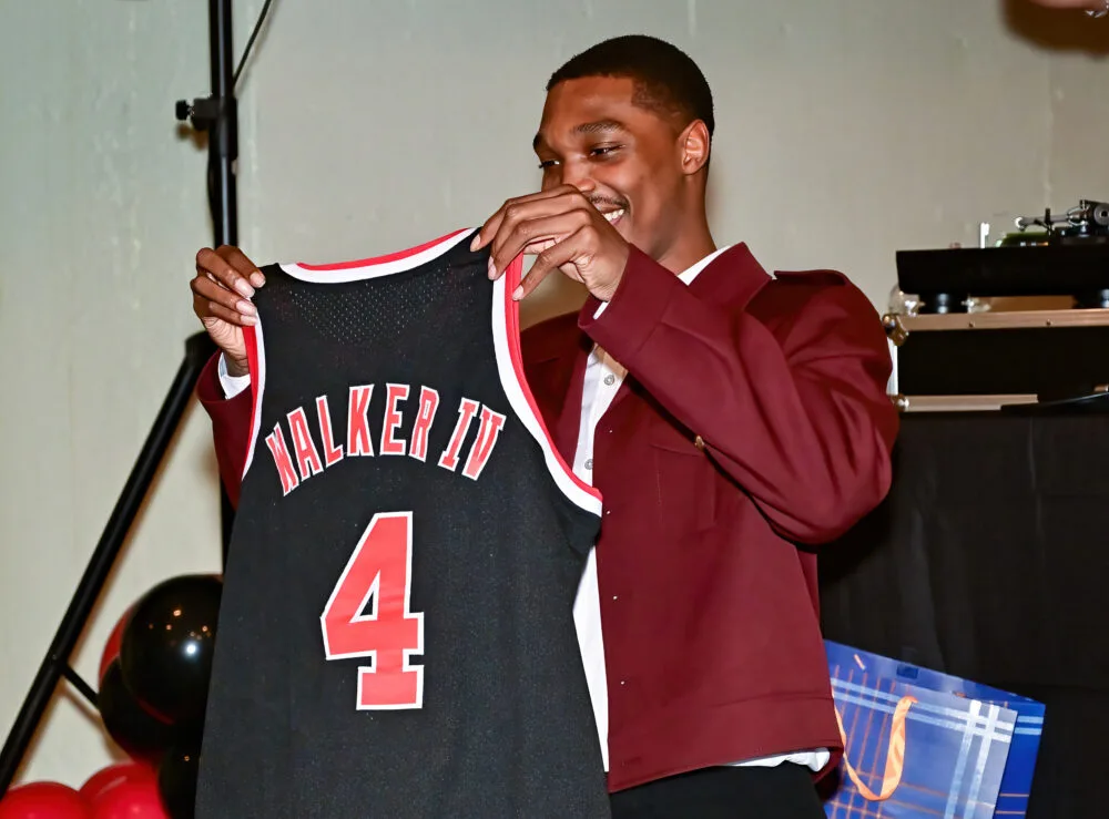 Lonnie Walker IV holding a Walker IV number 4 jersey
