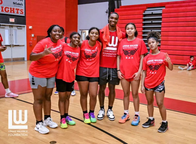 Girls basketball campers posing together in Foundation camp shirts