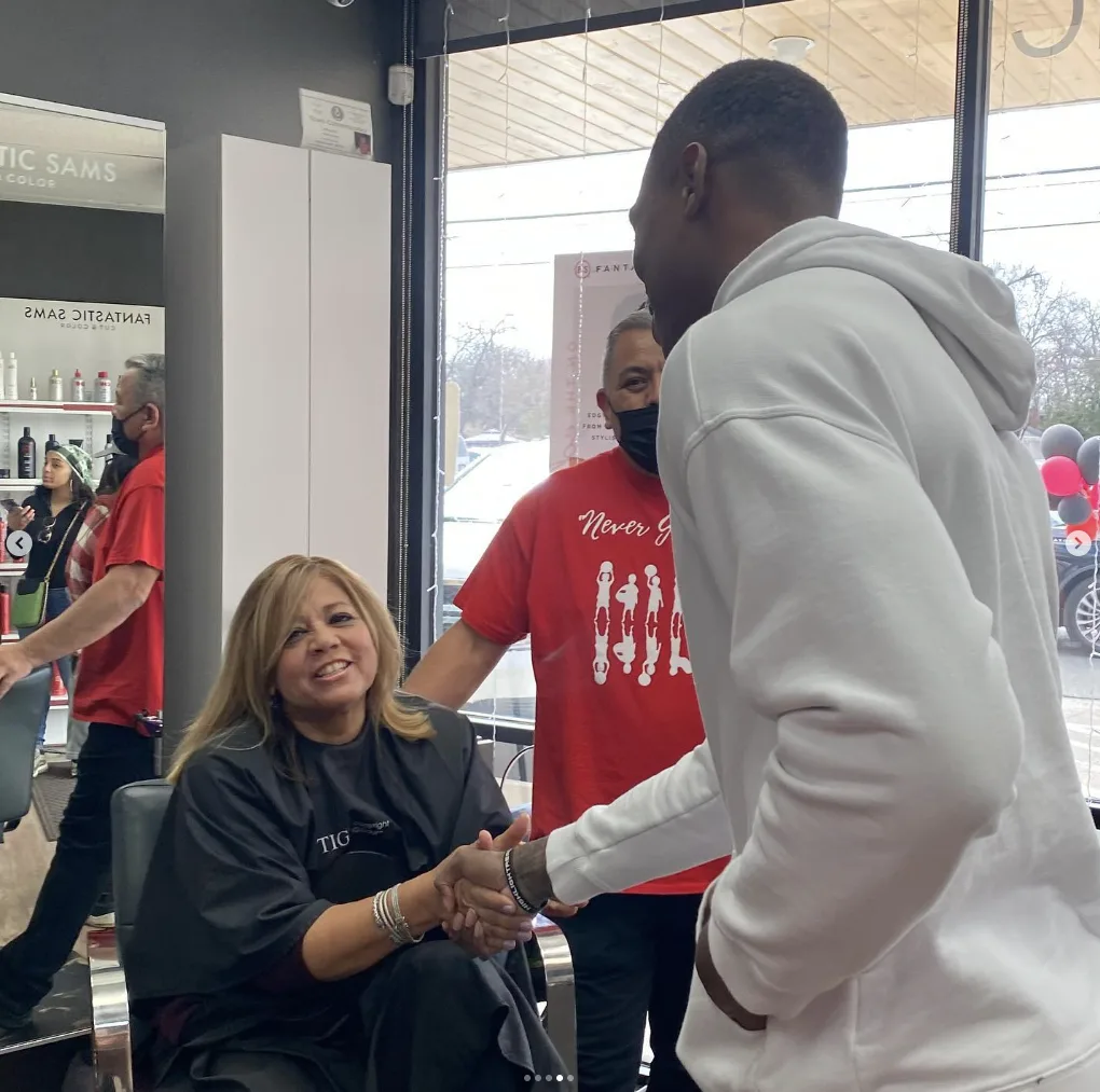 Lonnie Walker IV greeting a stylist at a free back-to-school haircut event
