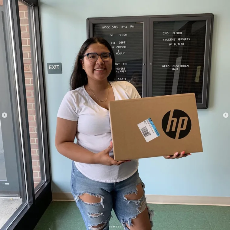 A graduating senior holding her laptop award