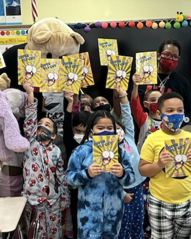 Students holding up books at a school reading event