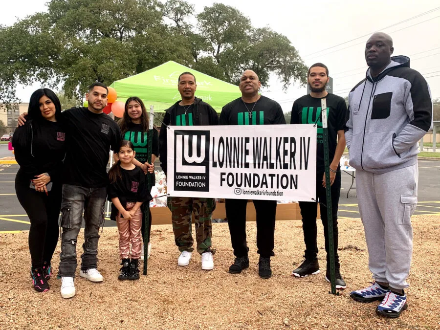 Volunteers holding a Lonnie Walker IV Foundation banner at the Turkeys for Teachers giveaway